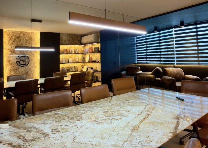 Sala de reuniões do escritório GB Advocacia Criminal, com mesa de mármore e acervo de livros